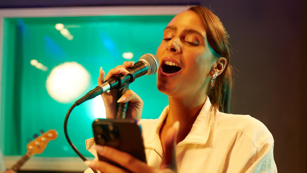 Woman Singing While Holding Her Phone